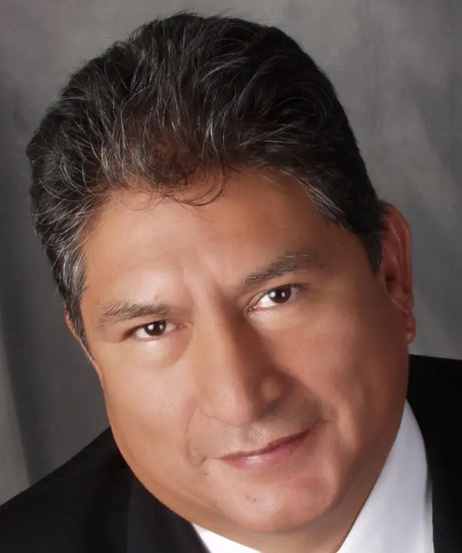 A man in suit and tie with a black background