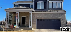 A house with two garage doors and a blue door.