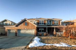 A large brick house with snow on the ground.