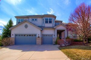 A large house with two garage doors and a driveway.